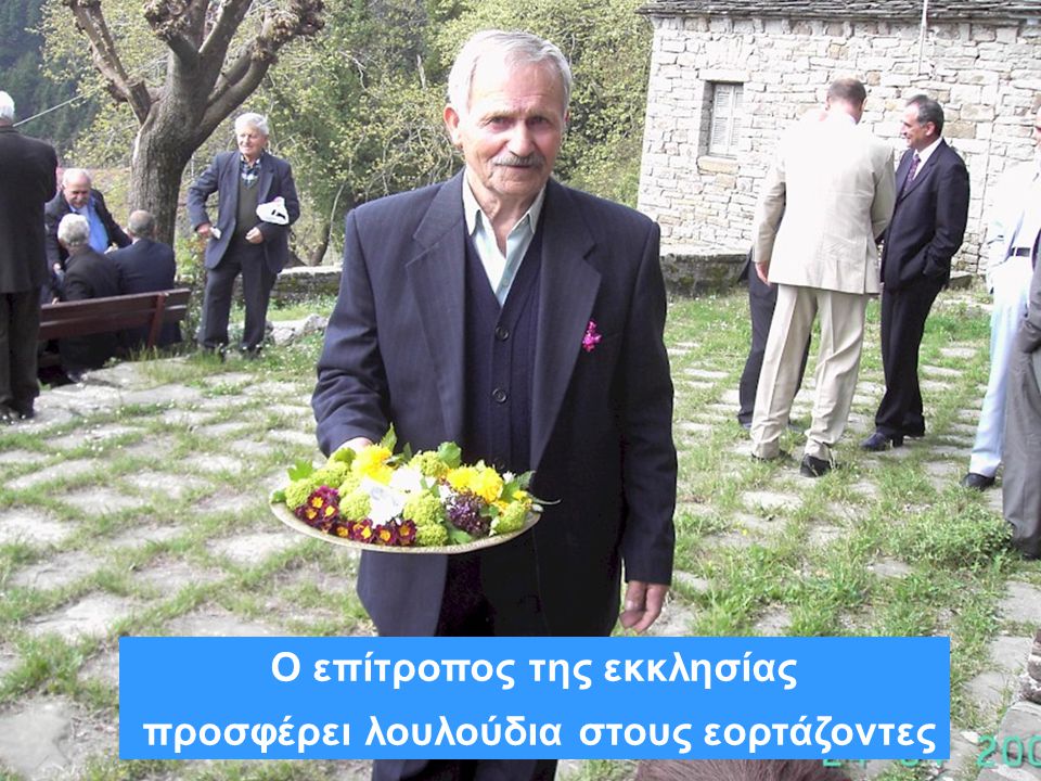Ο επίτροπος της εκκλησίας προσφέρει λουλούδια στους εορτάζοντες